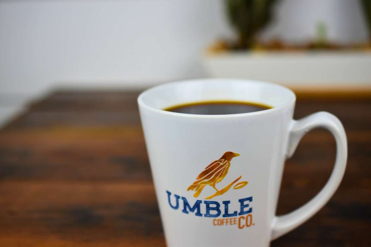 White mug with 'Umble Coffee Co.' logo on a wooden surface