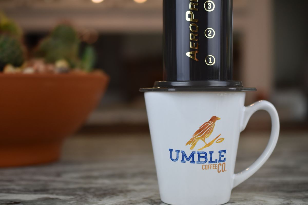 AeroPress coffee maker on a Umble Coffee Co. mug with a blurred background