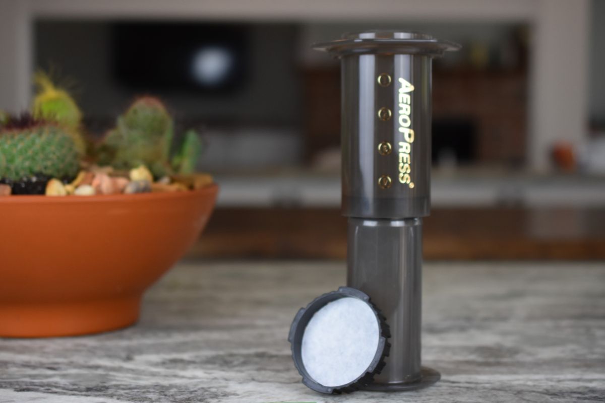  AeroPress coffee maker on a table with a blurred indoor background