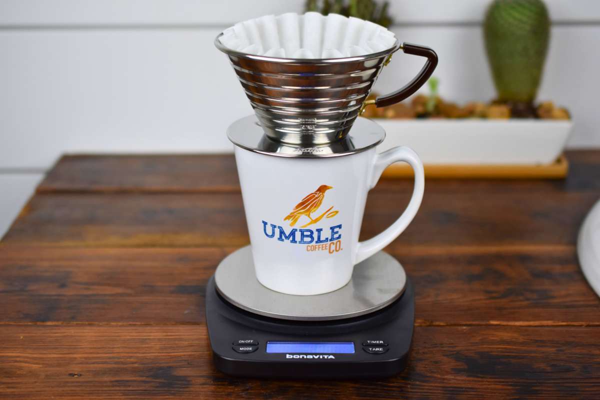 Coffee brewing setup with a white mug labeled 'Umble Coffee' on a digital scale.